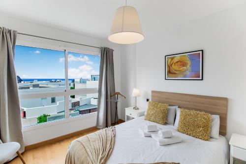 una camera da letto con un letto e una grande finestra di Agaete Serenity 2BR ad Agaete