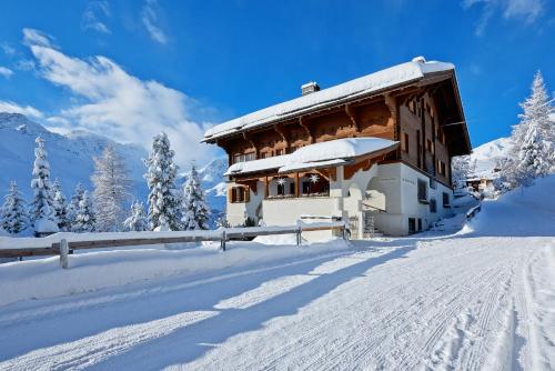 un edificio su una montagna innevata con neve di Hotel Stoffel - adults only a Arosa
