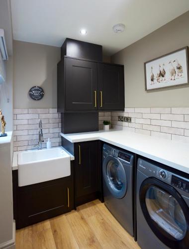 a kitchen with a sink and a washing machine at Fig Tree House in Great Malvern