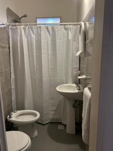 a bathroom with a toilet and a sink at Natullins Apartment in Ezeiza