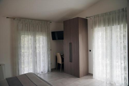 a bedroom with a bed and a cabinet with windows at B&B Arco Dei Sogni in Celano