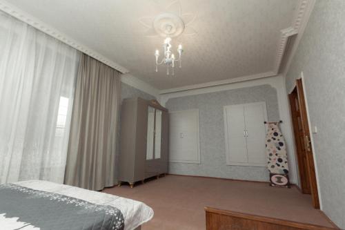 a bedroom with a bed and a chandelier at Cozy Home Gabala in Gabala