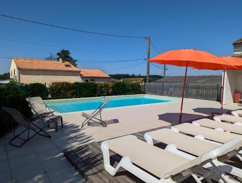 - une piscine avec des chaises et un parasol dans l'établissement La Bonne Chauffe - La Longère, à Verrières