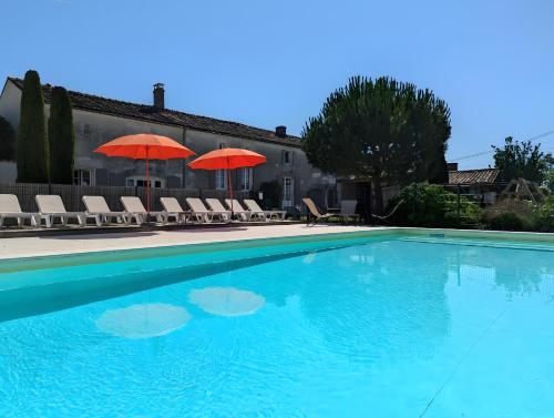 a large swimming pool with chairs and umbrellas at La Bonne Chauffe - Serpentin in Verrières