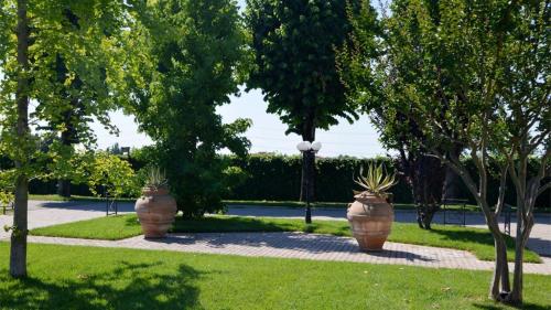 two large pots with plants in them in a park at Albergo Aurora in Castenaso