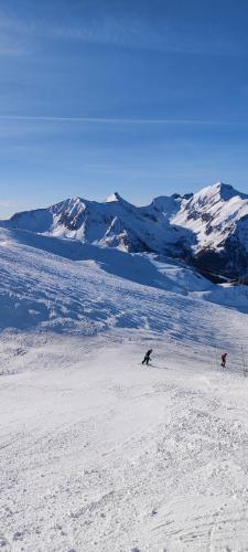 2 personnes skier sur une piste enneigée avec des montagnes dans l'établissement Grand studio 4 pers au pied des pistes - Wifi - parking, aux Orres
