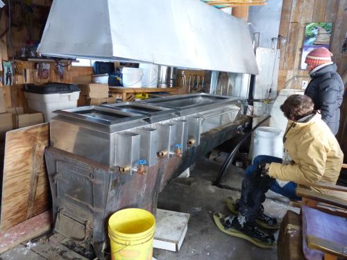 two people working in a kitchen with a stove at Bed and Breakfast Du Repos in Saint Quentin