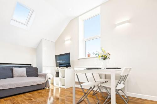 a white living room with a table and a couch at Two bed Apartment in Leytonstone in London