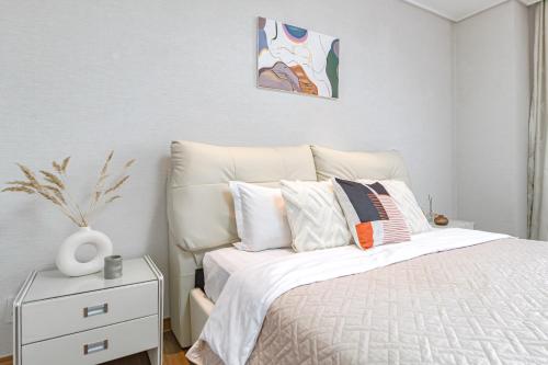 een slaapkamer met een wit bed en een wit nachtkastje bij HIGHVILL PARK in Astana