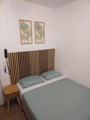 un lit dans une chambre avec deux tableaux au mur dans l'établissement Hôtel de l'Europe, à Paris