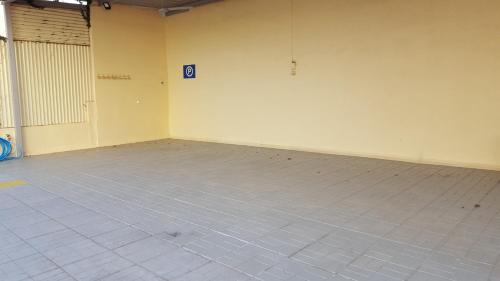 an empty room with a tile floor and a white wall at Stella Family Apartments in Síndos