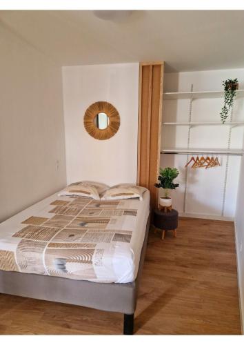 une chambre avec un lit et un miroir au mur dans l'établissement Appartement de charme proche de la mer, à Palavas-les-Flots