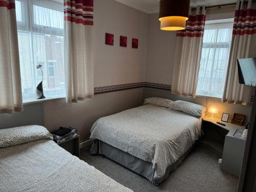a bedroom with two beds and a window at West Vale Villa in Blackpool