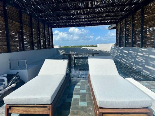 two white benches sitting on top of a building at ZEL-VA Tulum Apartments in Tulum