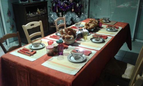 una mesa con un mantel rojo con comida. en Kerstunt Chambre d'hôtes Relais Motards, en Guérande