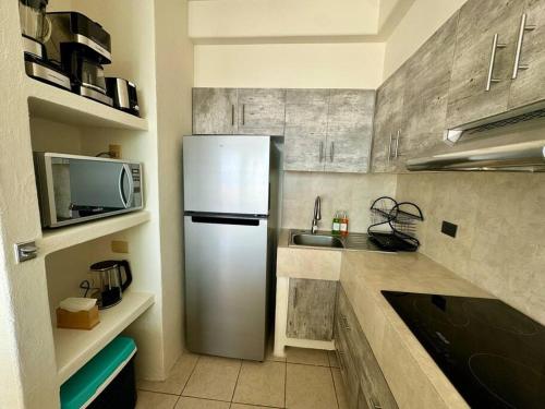 a kitchen with a refrigerator and a microwave at Vista al Mar, Terraza y Albercas in Manzanillo