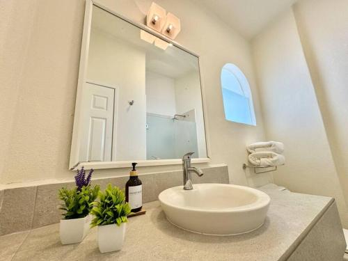 a white bathroom with a sink and a mirror at Vista al Mar, Terraza y Albercas in Manzanillo