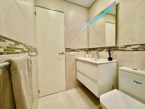 ein Badezimmer mit Waschbecken und Spiegel in der Unterkunft BLUEBIRD Luxury apartment in Las Americas in Playa de las Americas