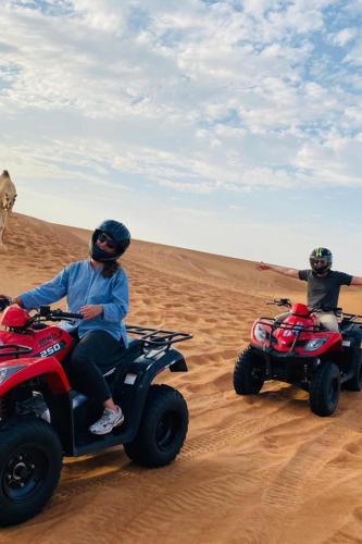 two people riding on atvs in the desert at Camp Golden Desert Morocco in Mhamid