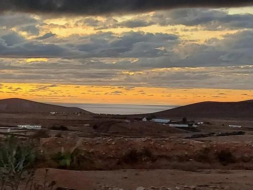 a sunset in the desert with the sky and the ocean at Casa Dayaday in Puerto del Rosario