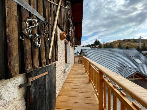 une passerelle en bois sur le côté d'un bâtiment dans l'établissement Homency - Chalet La Gaule, à L'Alpe-d'Huez