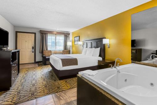 a hotel room with a bed and a bath tub at Best Western of Harbor Springs in Harbor Springs