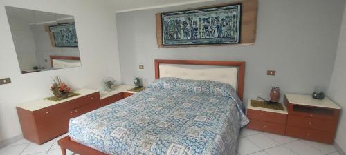 a bedroom with a bed and two dressers and a mirror at Tommaso Domus in Vasanello