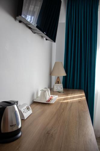 a table with a toaster and a lamp on it at Casa Muntenească Alessandro in Piteşti