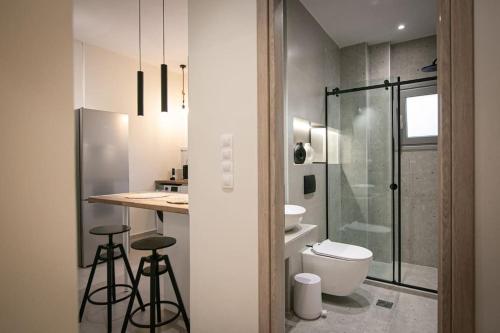 a bathroom with a toilet and a sink and a shower at Dormu in Tríkala