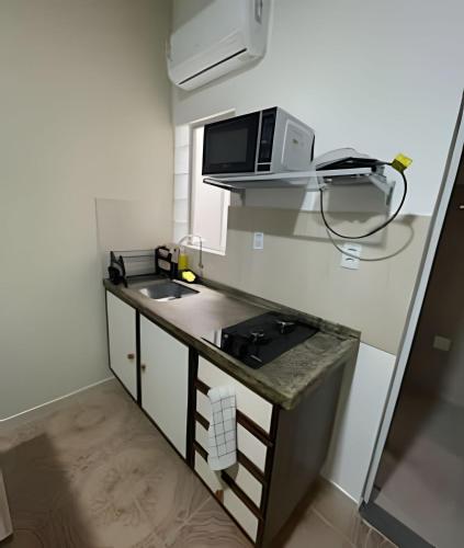 a small kitchen with a sink and a microwave at Residencial JC II sua casa em Belém do Pará in Belém