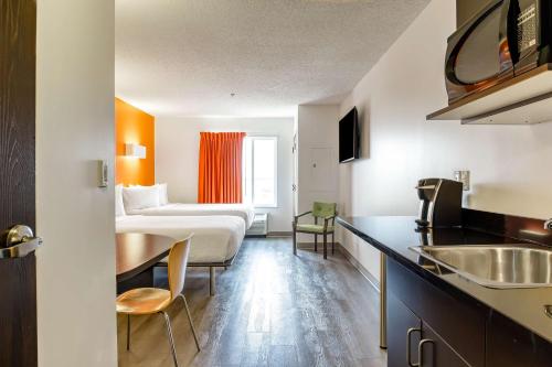 a hotel room with a couch and a table at Motel 6-Headingley, MB - Winnipeg West in Winnipeg