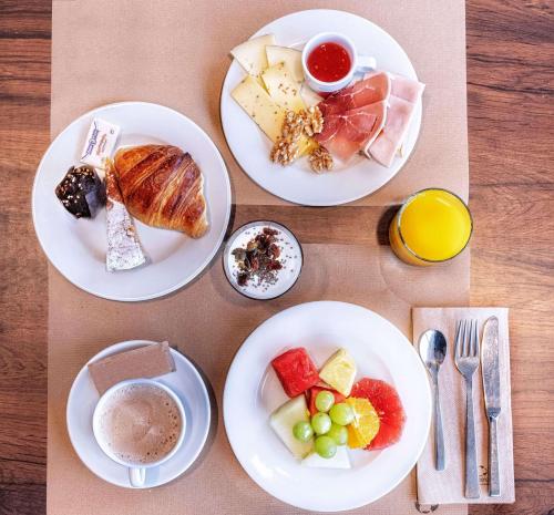three plates of food on a table with plates of food at Hotel Zentral León in León