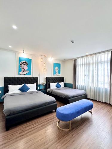 a bedroom with two beds and a ottoman at RL Boutique Dalat in Da Lat