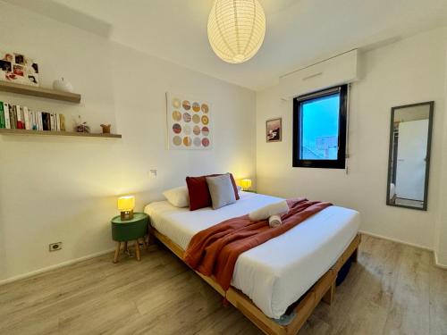 a bedroom with a large bed and a window at Le Nantais, centre de Rennes avec garage privé in Rennes