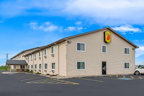 a large building in a parking lot at Super 8 by Wyndham Council Bluffs IA Omaha NE Area in Council Bluffs