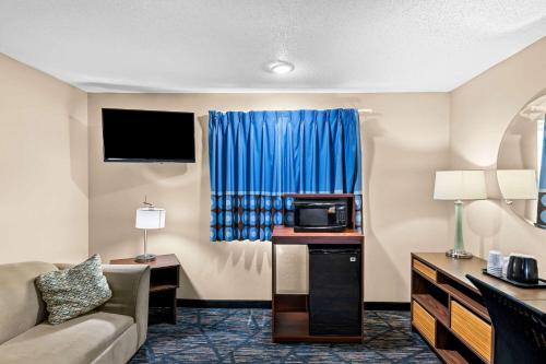 a hotel room with a couch and a microwave at Super 8 by Wyndham Council Bluffs IA Omaha NE Area in Council Bluffs