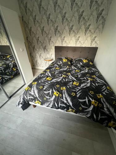 - un lit avec une couette noire et jaune dans l'établissement Appartement Hyeres 10 min plage, à Hyères