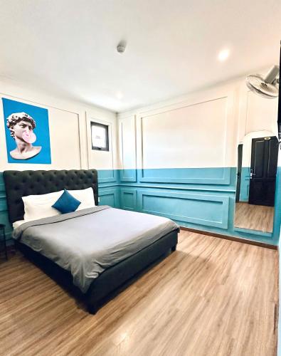 a bedroom with a bed with blue walls at RL Boutique Dalat in Da Lat