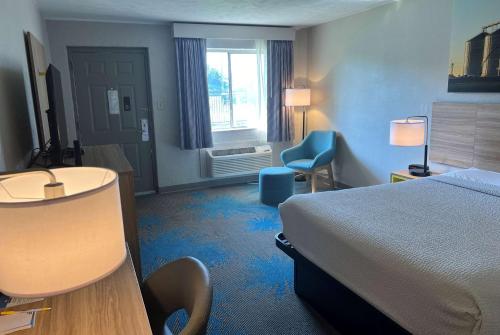 a hotel room with a bed and a desk and chair at Days Inn by Wyndham Hays in Hays