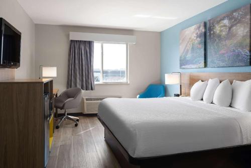 a hotel room with a bed and a window at Days Inn by Wyndham Neenah in Neenah