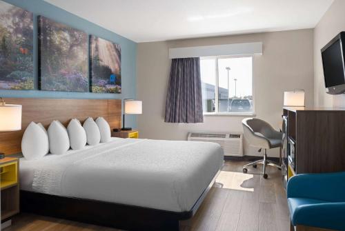 a hotel room with a bed and a television at Days Inn by Wyndham Neenah in Neenah