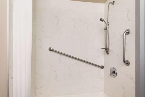 a shower with two grab bars in a bathroom at Travelodge by Wyndham Calgary South in Calgary