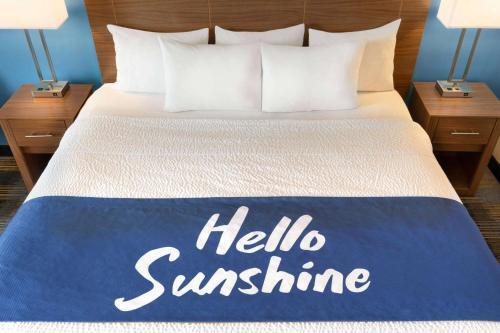 a bed with a hello sunshine sign on it at Days Inn by Wyndham Middletown/Newport Area in Middletown
