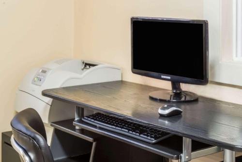 a desk with a computer monitor and a keyboard and mouse at Days Inn by Wyndham Middletown/Newport Area in Middletown