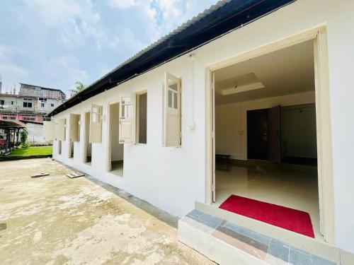una fila de ventanas en un edificio blanco en Nagaon Homestay, en Nowgong