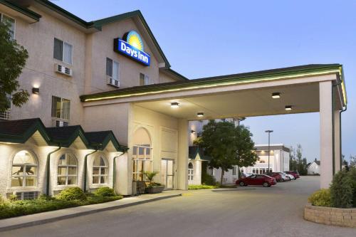 a hotel with a sign on the front of it at Days Inn by Wyndham Steinbach in Steinbach