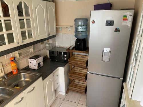 a kitchen with a refrigerator and a sink at Casa en condominio equipada para 8 personas in Calama