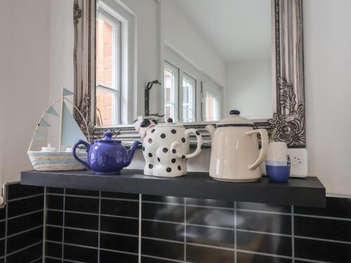 un comptoir avec des théières et un miroir dans l'établissement 18 Chamberlaine Road, à Weymouth