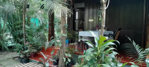 a patio with a table and a bunch of plants at Marari Umapathi Beach Villa in Mararikulam