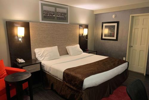 a bedroom with a large bed in a hotel room at Ramada by Wyndham Rockville Centre in Rockville Centre